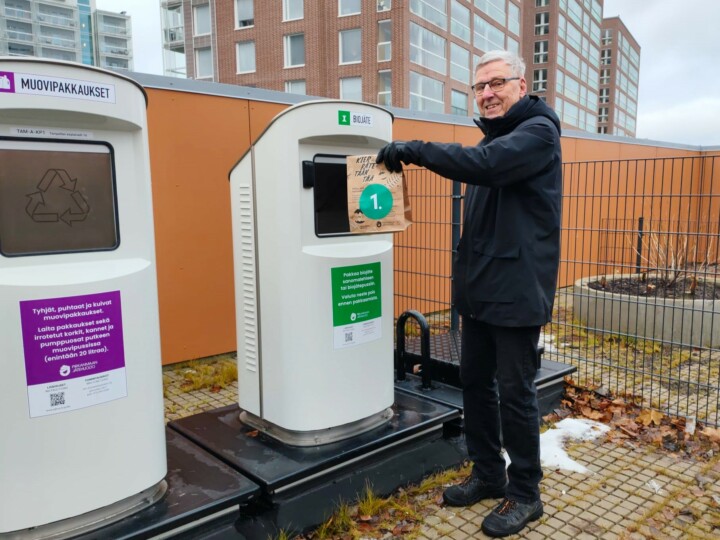 Asukas Tapio Lindroos pudottaa biojätepussin putkikeräyksen syöttöpisteeseen.