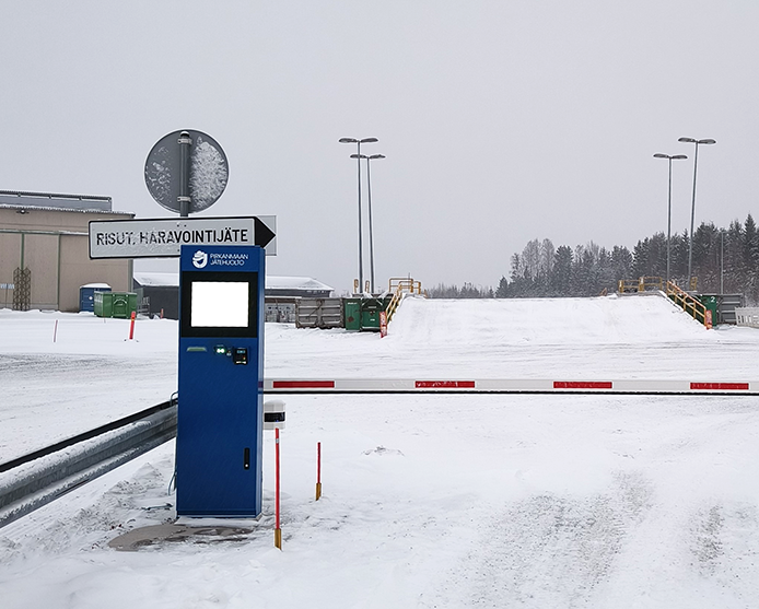 Sininen maksulaite, jossa on näyttöruutu, on jätekeskuksen portilla.