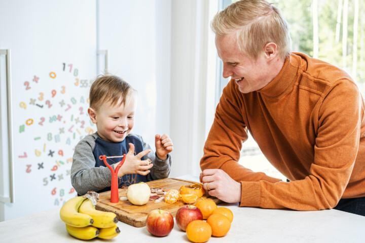 isä ja poika kuorivat omenaa yhdessä
